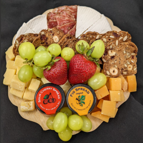 Charcuterie board with fruit, cheese, crackers and jam